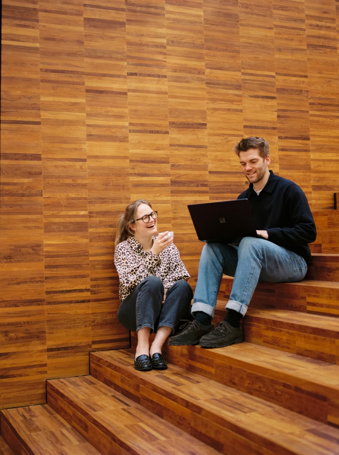 Twee ondernemers bekijken samen hun financiële plan op een laptop